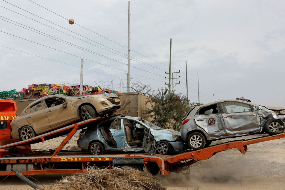 Vehicles destroyed by Hamas during the October 7 attack on Israel, are transported by a truck in a field near the Israel-Gaza border, Israel October 29, 2023. — Reuters pic