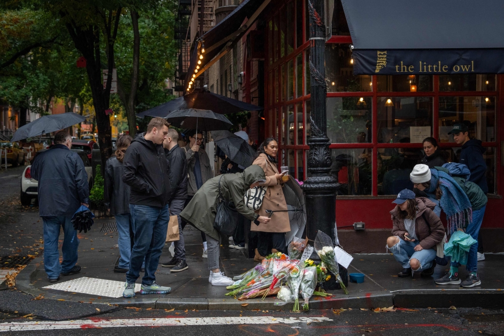 Floral tributes are left for actor Matthew Perry outside the apartment building which was used as the exterior shot in the TV show ‘Friends’ in New York. — AFP pic