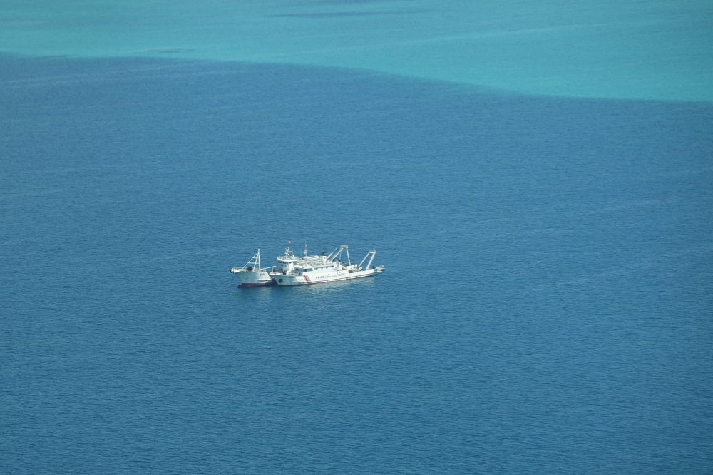 This photo taken on September 28, 2023 shows an aerial view of Chinese coast guard ships anchored inside the lagoon of the Chinese-controlled Scarborough Shoal during a maritime surveillance flight by the Philippine Bureau of Fisheries and Aquatic Resources (BFAR) over disputed waters of the South China Sea. — AFP pic