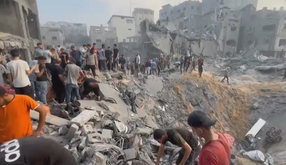 This image grab taken from AFPTV video footage shows Palestinians looking for survivors in a crater following an Israeli strike on a refugee camp in Jabalia on the southern Gaza Strip, on October 31, 2023, amid ongoing battles between Israel and the Palestinian Hamas movement. — AFP pic