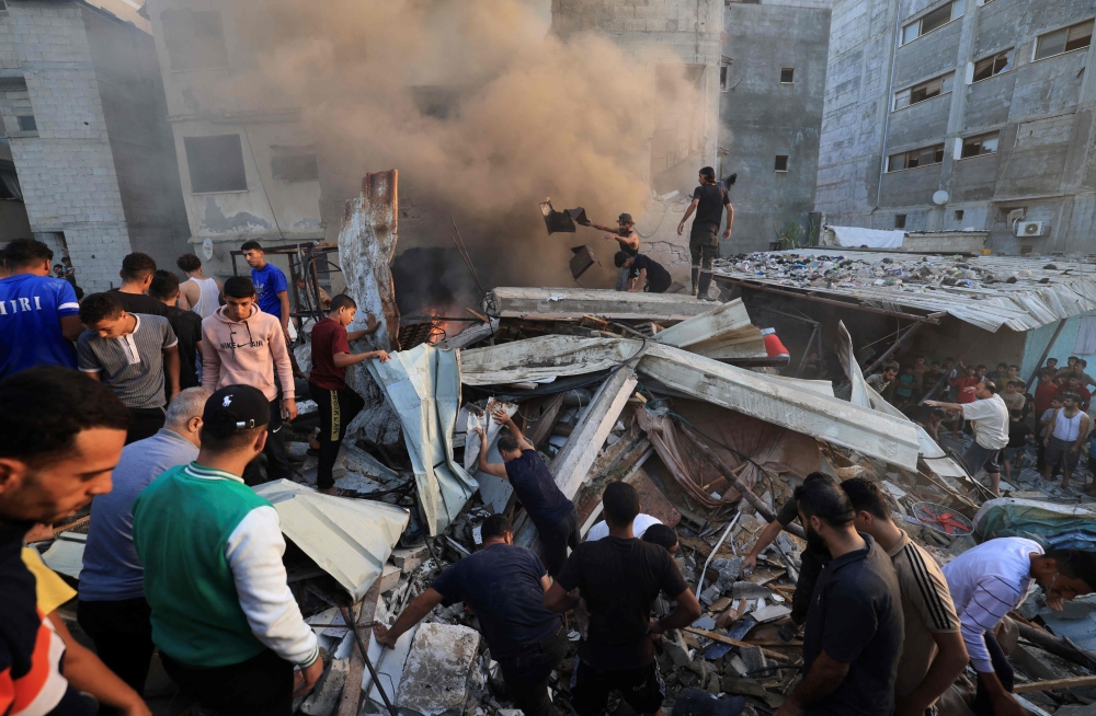 Palestinian search through the rubble of a collapsed building looking for victims and survivors following a strike by the Israeli military on Khan Yunis in the southern Gaza Strip on November 4 , 2023, amid the ongoing battles between Israel and the Palestinian group Hamas. — AFP pic