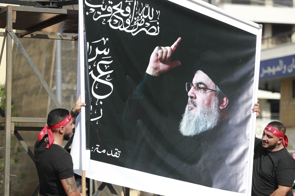 Supporters of the Lebanese Shiite movement Hezbollah hold a large image of its leader Hassan Nasrallah during his  televised speech in the Lebanese capital Beirut’s southern suburbs on November 3, 2023. — AFP pic