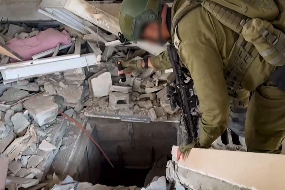 This screen grab taken from a handout footage released by the Israeli army on November 3, 2023, shows an Israeli soldier checking what it says is the entrance to a tunnel used by the Palestinian Hamas movement in the Gaza Strip, as battles between Israeli forces and Hamas continue. — AFP pic