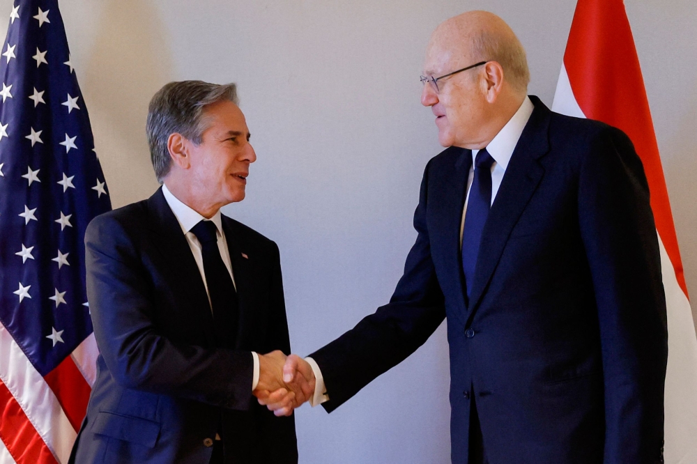 US Secretary of State Antony Blinken shakes hands with Lebanon’s caretaker prime minister Najib Mikati at a hotel during a day of meetings, amid the ongoing conflict between Israel and the Palestinian group Hamas, in the Jordanian capital Amman on November 4, 2023. — AFP pic