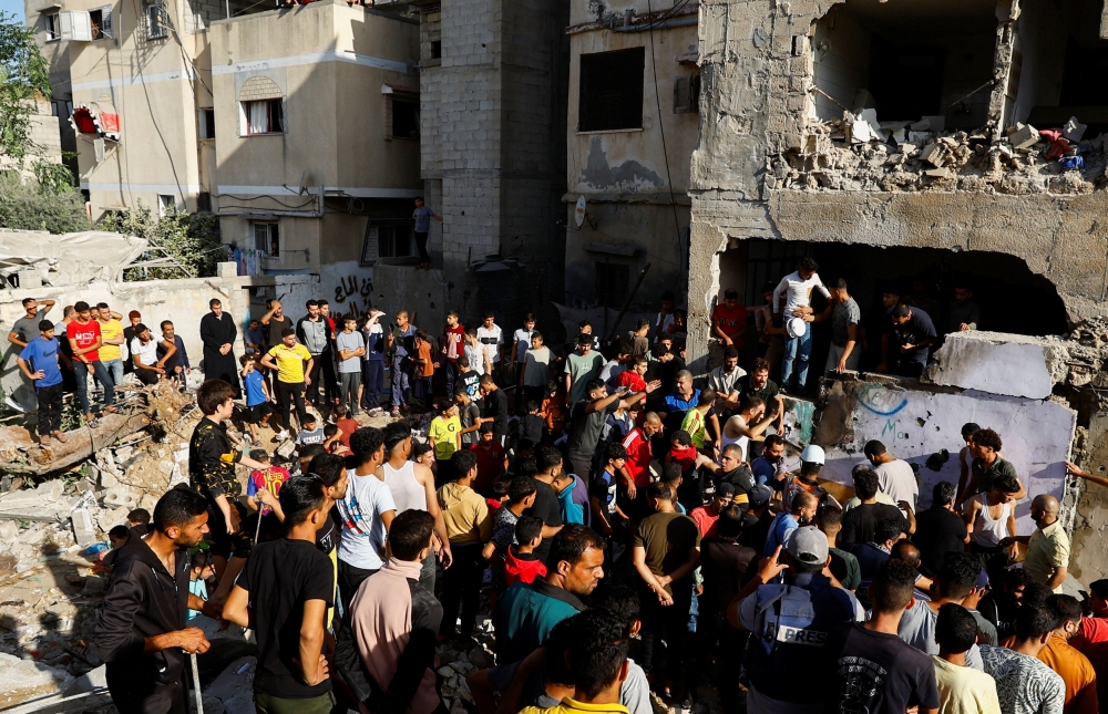 Palestinians gather at the site of Israeli strikes on a residential building, amid the ongoing conflict between Israel and Palestinian Islamist group Hamas, in Khan Younis in the southern Gaza Strip, November 4, 2023. — Reuters pic