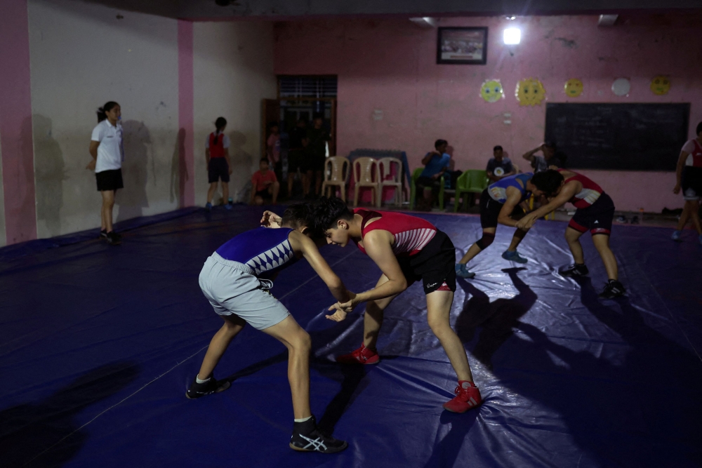 Students wrestle in bouts in the training room at the Altius wrestling school in Sisai. — Reuters pic