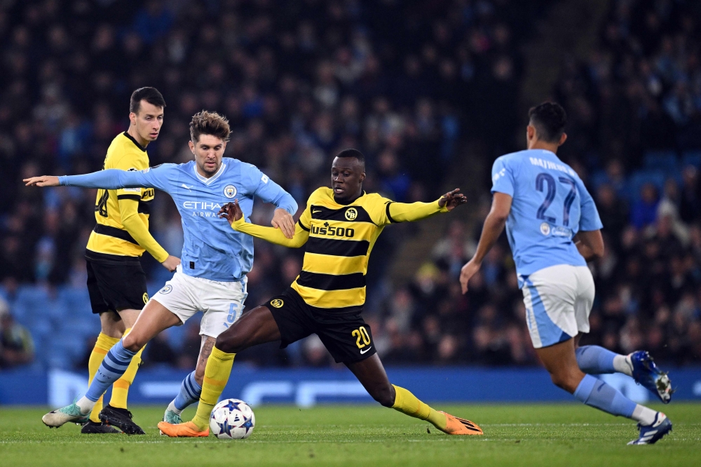 Manchester City's English defender #05 John Stones (2nd left) closes in on Young Boys' Senegalese midfielder #20 Cheikh Niasse during the Uefa Champions League Group B second leg football match between Manchester City and Young Boys at the Etihad Stadium in Manchester, north west England, on November 7, 2023. — AFP pic