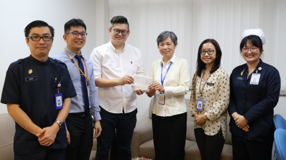 Dr Kelvin Yii (third left) hands over the cheques for the financial aid to Dr Ngian Hie Ung. — Borneo Post pic 