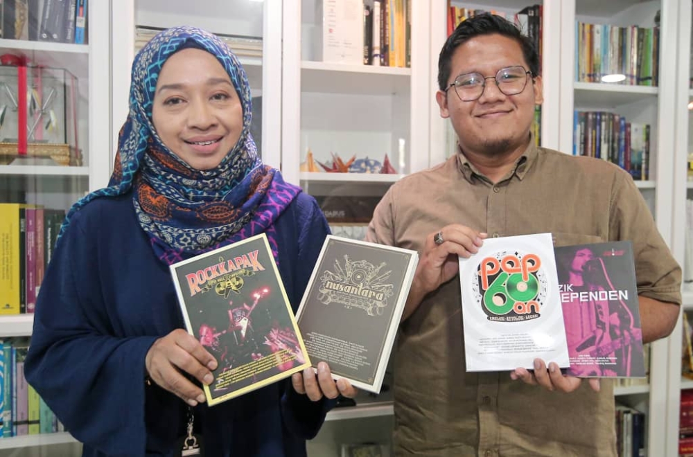 PORT (People Of Remarkable Talents) Ipoh general manager Nur Hanim Mohamed Khairuddin (left) and assistant manager Muhammad Hanif Baharul Wafi with books containing all papers presented during the Ipoh Music Symposium. — Picture by Farhan Najib