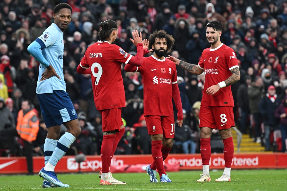 Liverpool's Egyptian striker Mohamed Salah (centre) is congratulated after scoring their second goal during the English Premier League football match between Liverpool and Brentford at Anfield in Liverpool November 12, 2023. — AFP pic