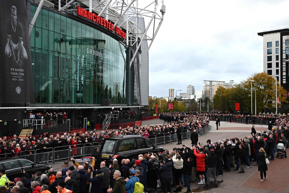 A hearse carrying the coffin of Manchester United and England great Bobby Charlton is driven past Old Trafford stadium. — AFP pic