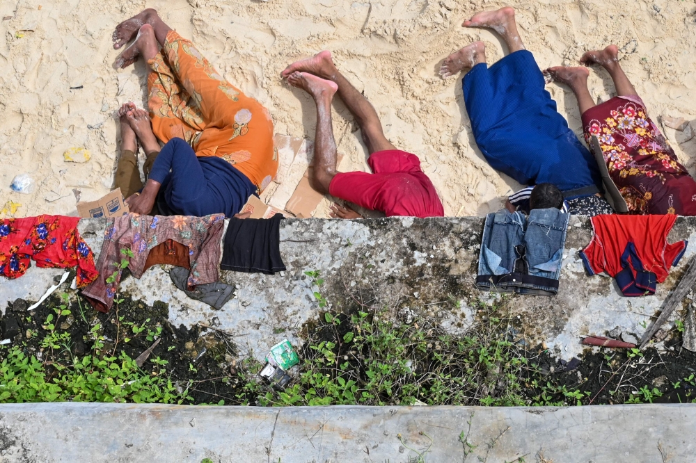 Newly-arrived Rohingya refugees rest on a beach in Sabang island, Aceh province on November 22, 2023. — AFP pic