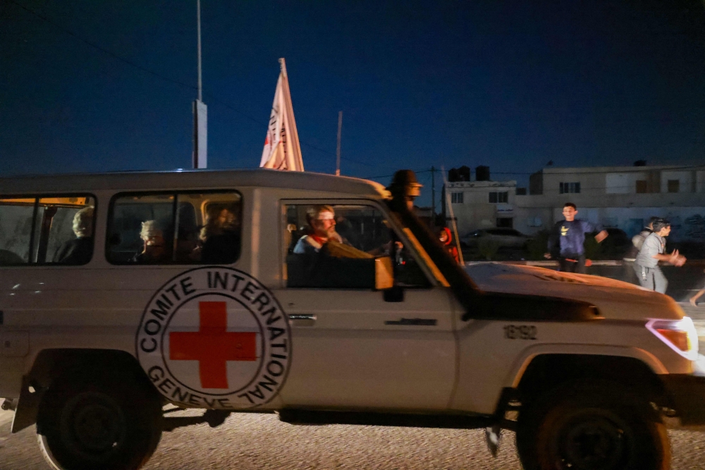 An International Red Cross vehicle reportedly carrying hostages released by Hamas crosses the Rafah border point in the Gaza Strip towards Egypt from where they would be flown to Israel to be reunited with their families, on November 24, 2023. — AFP pic