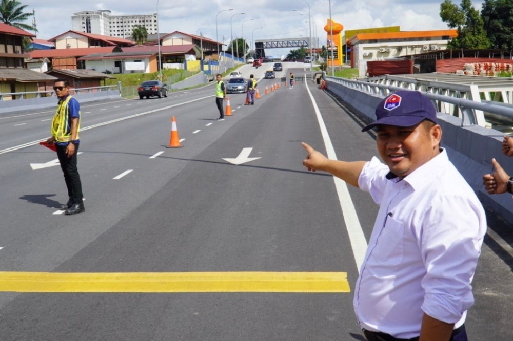 Johor Public Works, Transport and Infrastructure Committee chairman Mohamad Fazli Mohamad Salleh points to the completed bridge project that cuts across the Sungai Masai river to Jalan Masai Lama in Johor Baru which is now accessible to motorists. ― Picture by Ben Tan