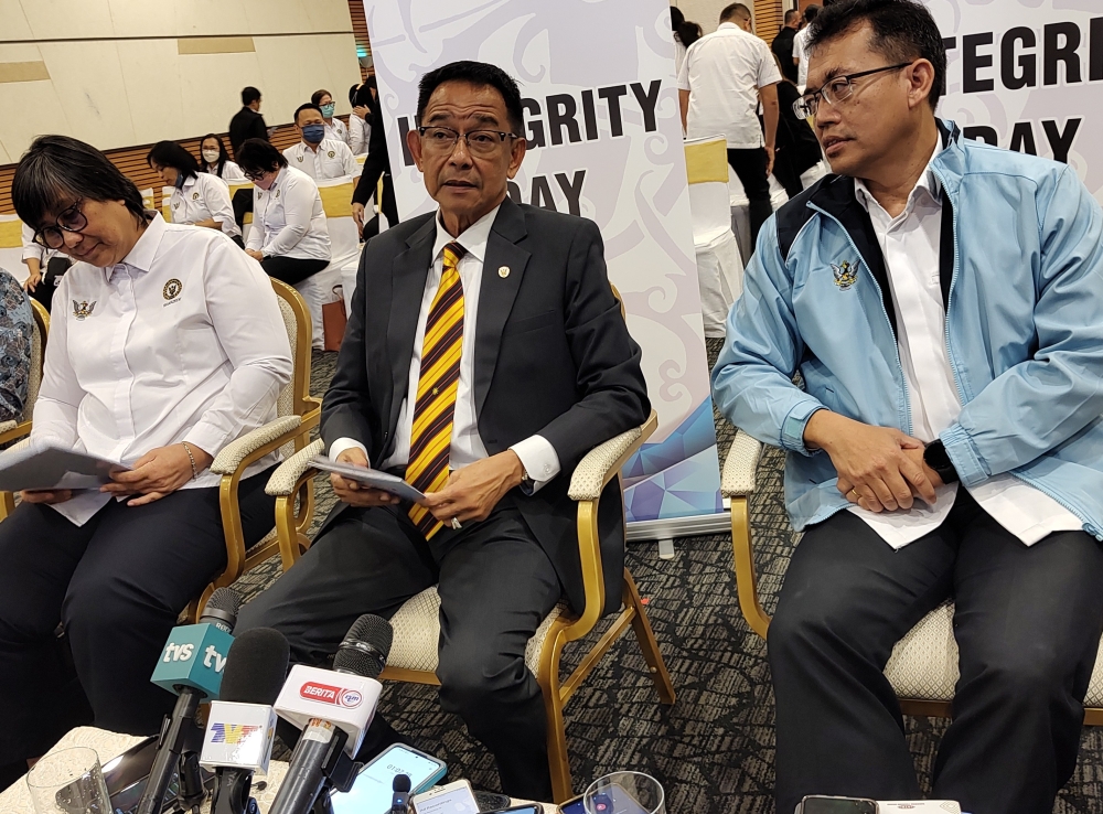 Tourism, Creative Industry and Performing Arts Minister Datuk Seri Abdul Karim Rahman Hamzah (centre) speaks to reporters after launching the Sarawak Tourism Board’s Integrity Policies Book and Integrity Day in Kuching December 7, 2023. — Picture by Sulok Tawie