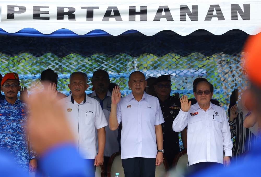 Minister in the Prime Minister’s Department (Sabah, Sarawak Affairs, and Special Duties) Datuk Armizan Mohd Ali takes a pledge at the vehicle presentation ceremony at the Sarawak APM Centre in Kuching, December 8, 2023. With him is Sarawak Deputy Premier Datuk Douglas Uggah Embas. — Bernama pic 