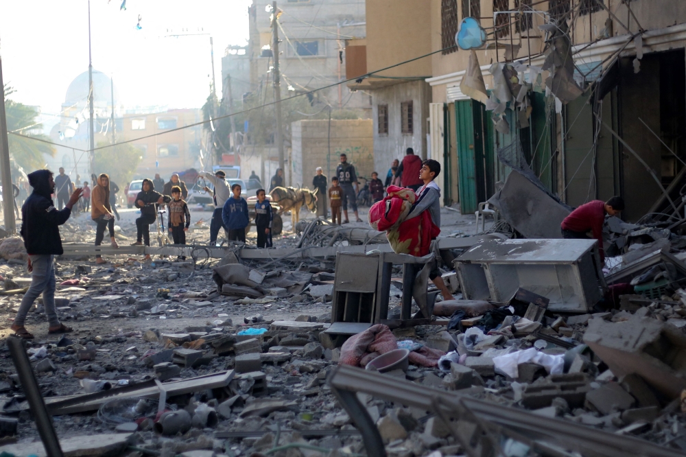 A boy salvaging some objects amid the rubble of a building hit bombed by Israel. — AFP pic