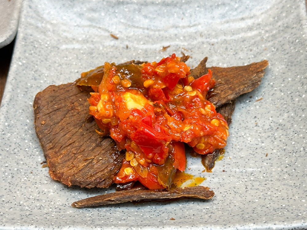 Dendeng Balado is the crispy, harder type that goes well with the red chillies 'sambal'