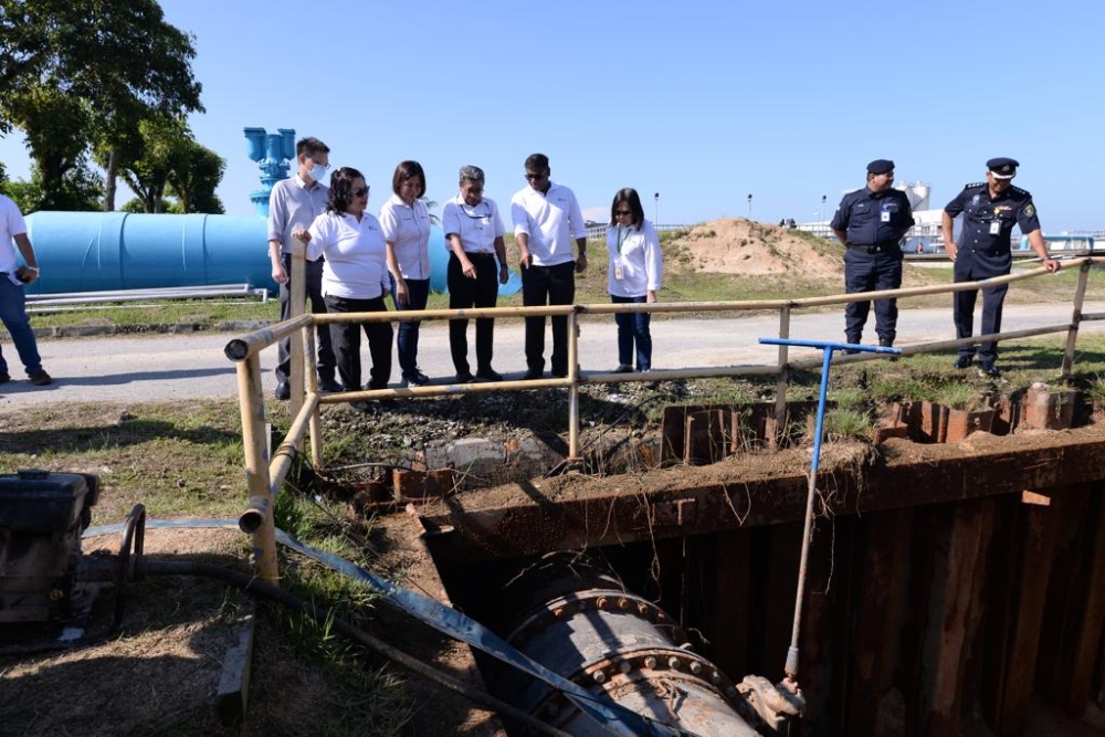 Penang Water Supply Corporation chief executive officer K. Pathmanathan and his team point to one of the valves at the Sungai Dua Water Treatment Plant on December 13, 2023. — Picture by Opalyn Mok