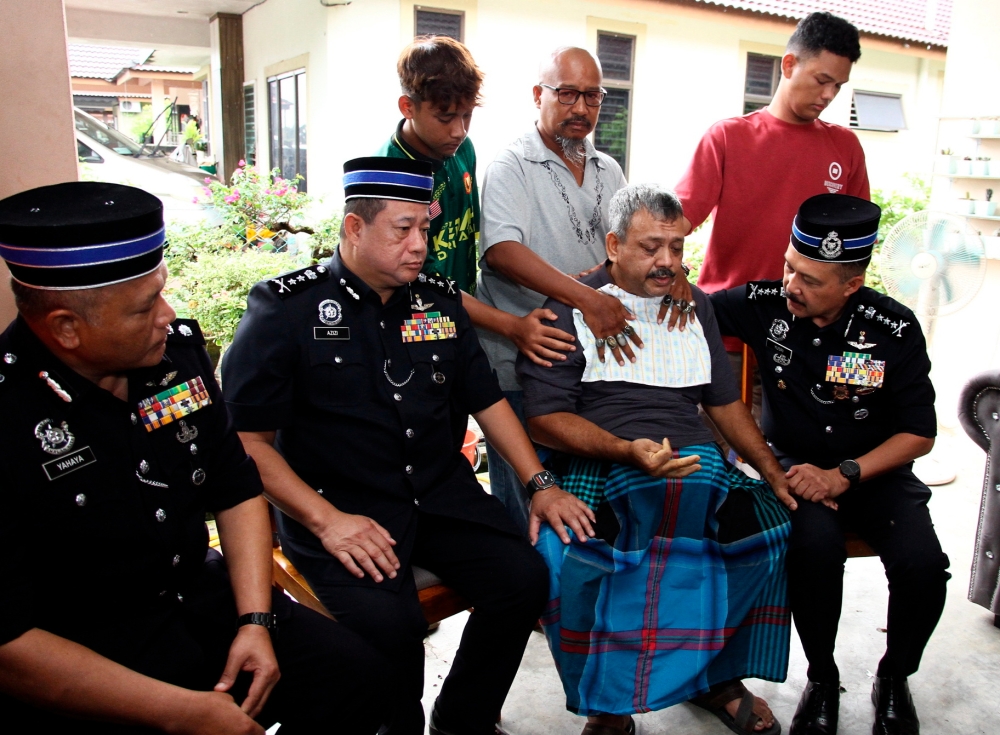 Perak police chief, Datuk Seri Mohd Yusri Hassan Basri consoling Muhd Zamrie Zainal Abidin (second right) who is the father to the Mohammad Zaharif Affendi who was killed in an accident involving a car near the Sekolah Kebangsaan Jati in Taman Chepor Sentosa in Chemor, Perak, December 16, 2023. — Bernama pic