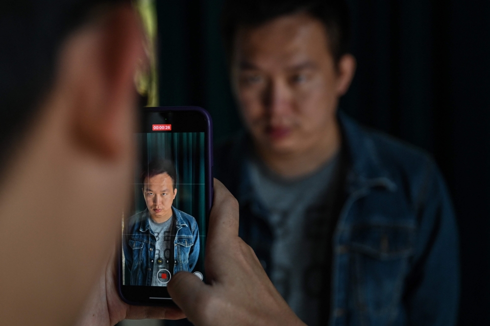 This photo taken on November 8, 2023 shows Zhang Zewei, founder of AI firm Super Brain which specialises in digital replicas of the dead, has footage of him taken by a colleague as he demonstrates the creation of a video using artificial intelligence in Jiangyin, China’s eastern Jiangsu province. — AFP pic 