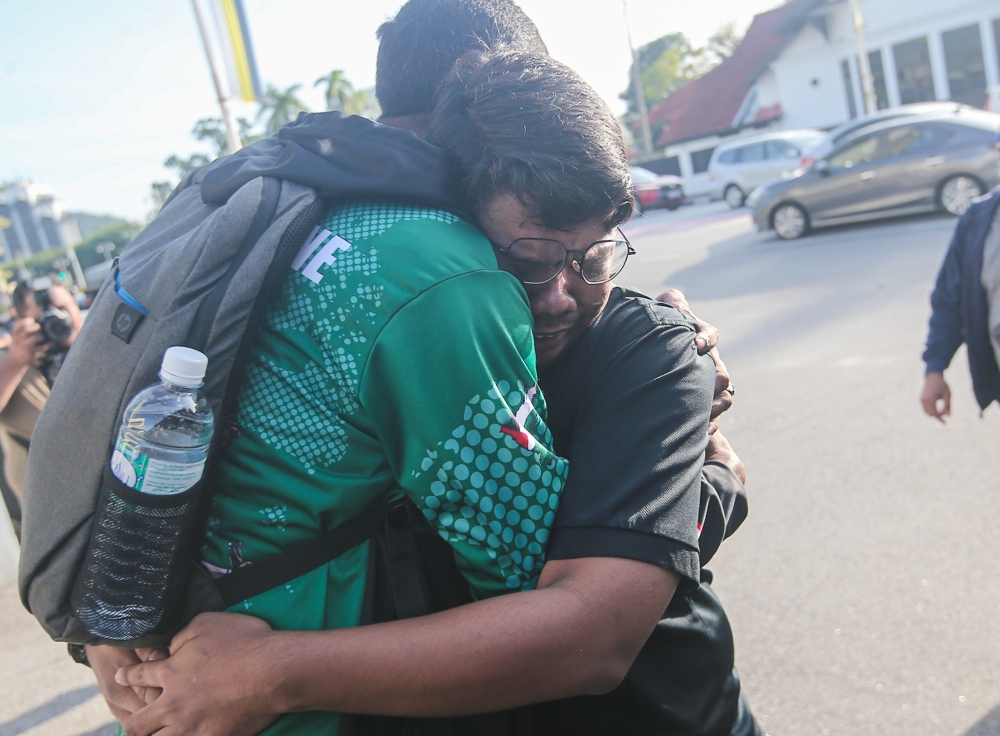 Muhammad Zaharif Affendi Muhd Zamrie’s brother Zarul Fitri (black shirt) at the Ipoh Magistrates’ Court where senior police officer Mohd Nazri Abdul Razak was charged with Zaharif Affendi’s murder, December 18, 2023. — Picture by Farhan Najib 