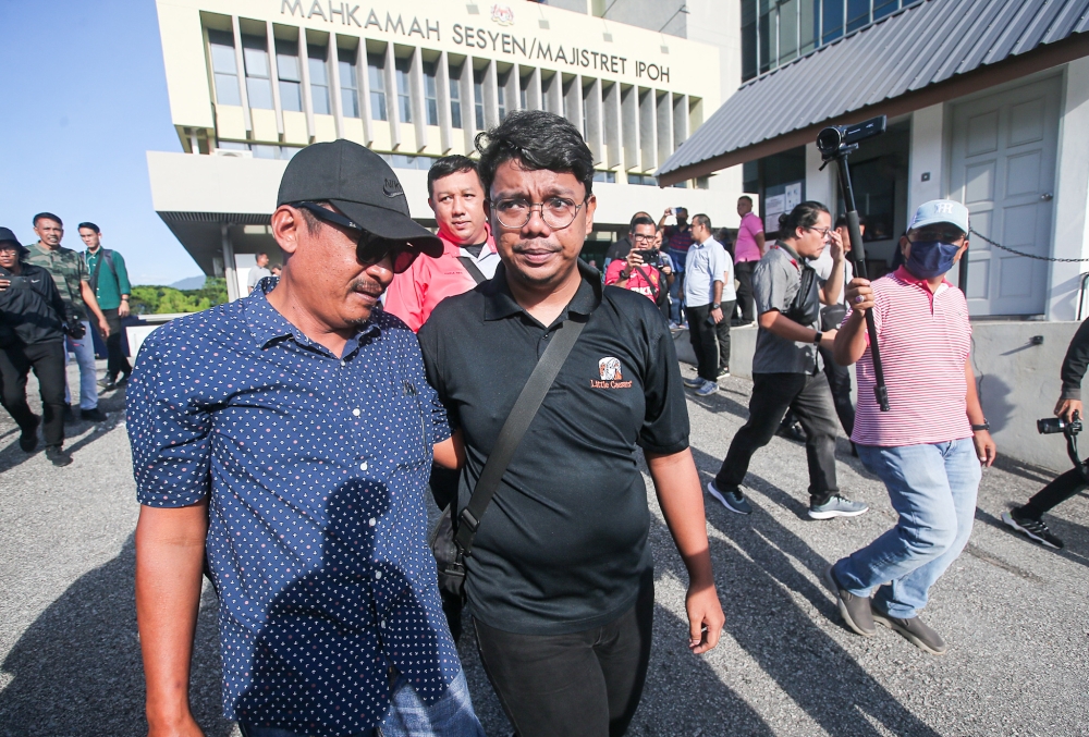 Muhammad Zaharif Affendi Muhd Zamrie’s brother Zarul Fitri ( black shirt ) and his uncle Abdul Razak Judin at the Ipoh Magistrates’ Court, December 18, 2023. — Picture by Farhan Najib 