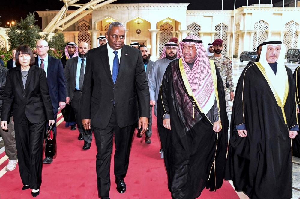 This handout picture released by Kuwait's Emiri Diwan shows Kuwaiti Defence minister Sheikh Ahmad al-Fahad al-Sabah (centre right) receiving US Secretary of Defense Lloyd (centre left) Austin at Kuwait International Airport in Kuwait City on December 17, 2023. — HO/Emiri Diwan/AFP pic