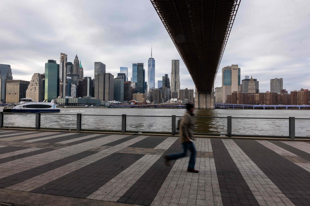 People walk under the heavily trafficked Brooklyn Bridge on January 03, 2024 in New York City. ― Reuters pic