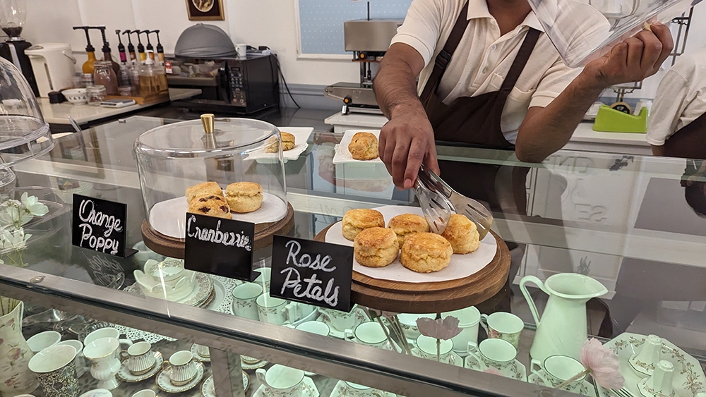 A staff member picks out a scone.