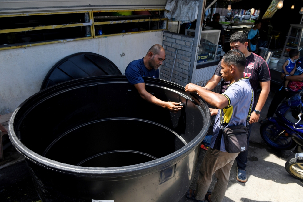 Workers are doing pipe installation work on large water tanks to store water in preparation for the water supply disruption that is expected to occur in Penang next week in George Town January 7, 2024. — Bernama pic