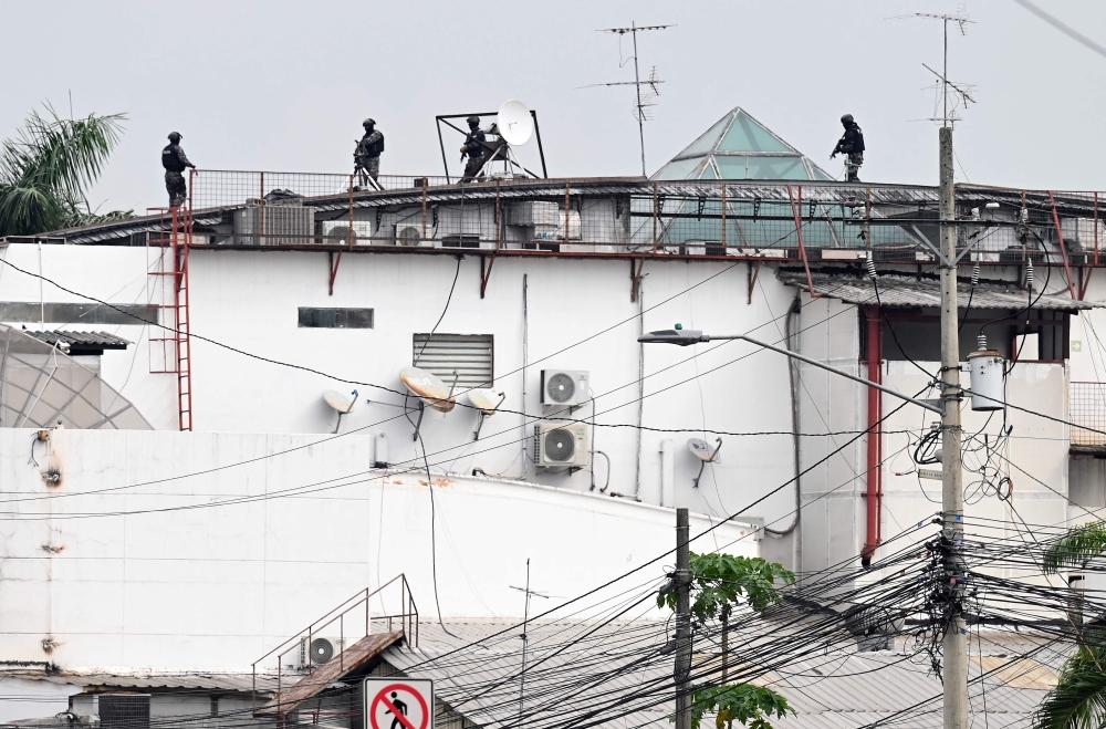 An Ecuadorean police squad approach the premises of Ecuador's TC television channel after unidentified gunmen burst into the state-owned television studio live on air on January 9, 2024, in Guayaquil, Ecuador, a day after Ecuadorean President Daniel Noboa declared a state of emergency following the escape from prison of a dangerous narco boss. — AFP pic 