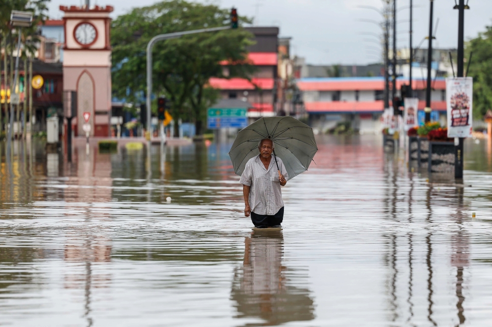 A local resident wades through the flood in Kota Tinggi city centre, January 10, 2024. — Bernama pic 