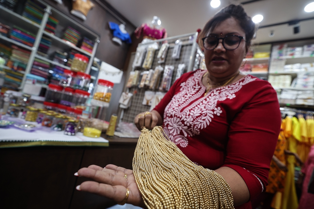 Letchumy Arumugam, owner of Sara Bombay Tailoring, shows off handmade ‘Aari’ work embroidery. — Bernama pic