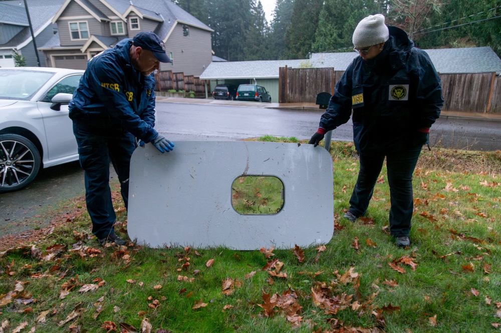 National Transportation Safety Board (NTSB) investigators examine the fuselage plug area of Alaska Airlines Flight 1282 Boeing 737-9 MAX, which was jettisoned and forced the aircraft to make an emergency landing, at a property where it was recovered in Portland, Oregon, US January 8, 2024. — NTSB handout pic via Reuters  