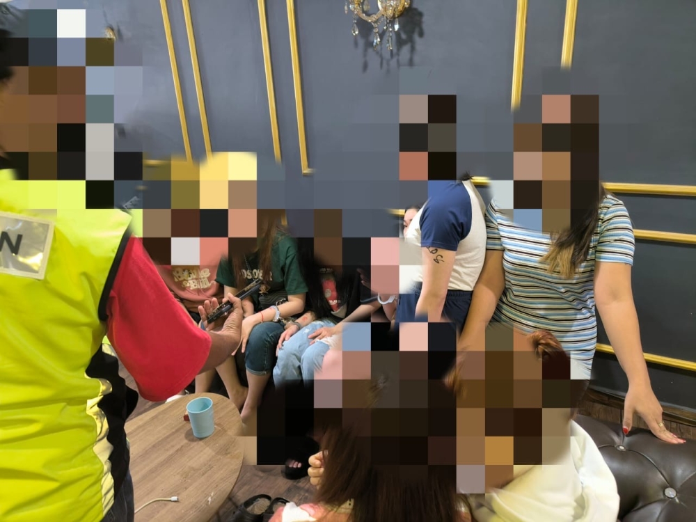 Johor Immigration Department enforcement officers speak to foreign women believed to be working as therapists during a raid at a massage centre in Masai, near Johor Baru, January 18, 2024. — Picture courtesy of the Johor Immigration Dept