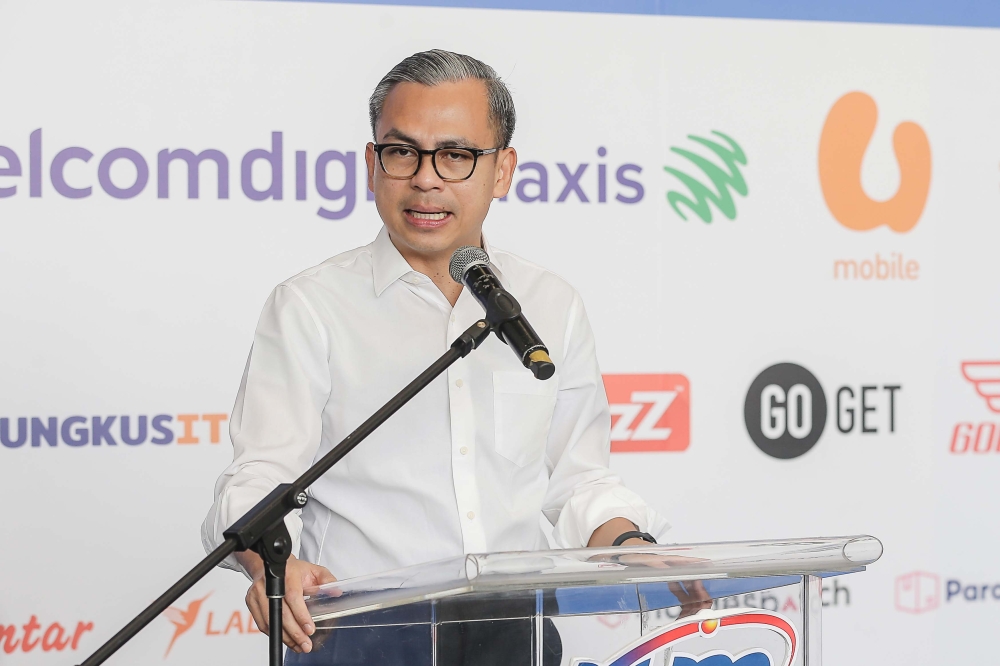 Communications Minister Fahmi Fadzil says the deal is part of the government’s commitment to improve the digital economy, adding that the package is expected to benefit some 200,000 p-hailing riders and drivers. — Picture by Sayuti Zainudin