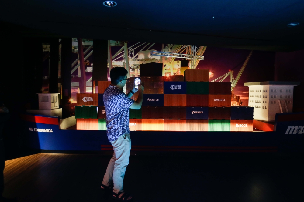 A visitor snaps a picture of one of the exhibits at the Economic Gallery at Sasana Kijang. — Picture by Sayuti Zainudin 