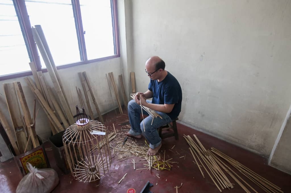 The making of a traditional lantern starts with  cutting and whittling down the bamboo. — Picture by Farhan Najib