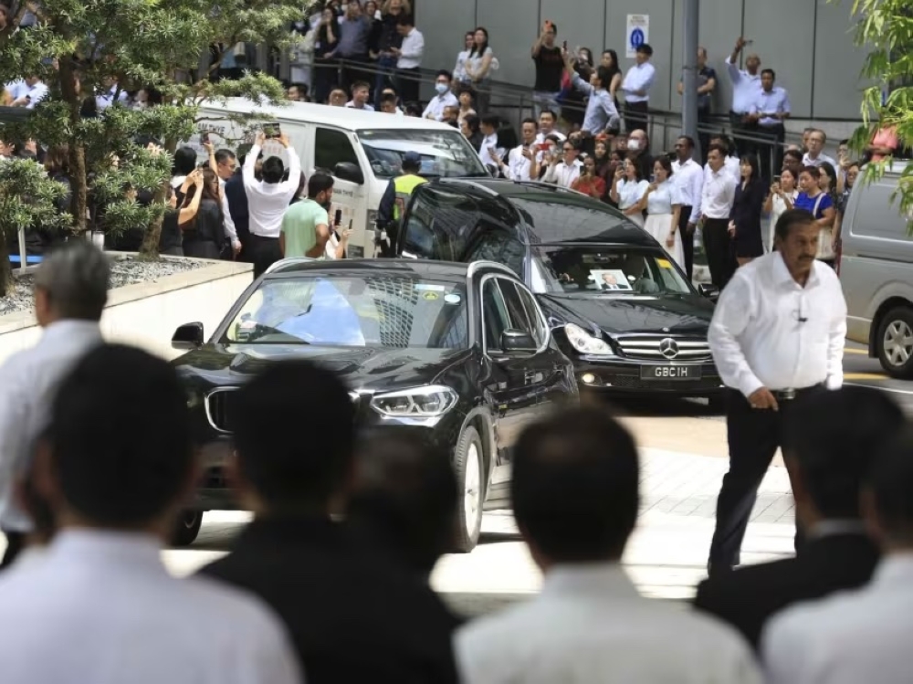 Wee Cho Yaw’s cortege arrives at UOB Plaza Atrium where United Overseas Bank employees gathered to pay their last respects on February 7, 2024. — TODAY pic