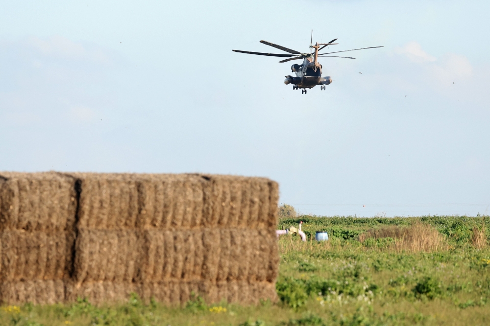 A picture taken from a position in southern Israel along the border with the Gaza Strip on February 9, 2024 shows an Israeli military helicopter flying over the border amid continuing battles between Israel and the militant group Hamas. — AFP pic