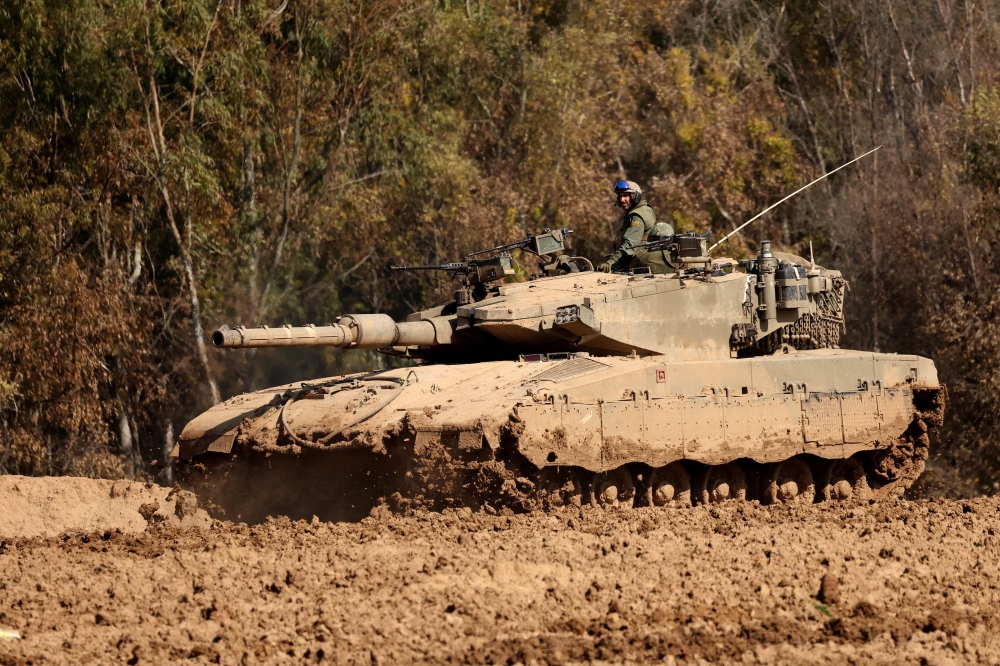 A picture taken from a position in southern Israel along the border with the Gaza Strip on February 9, 2024, shows an Israeli tank rolling amid continuing battles between Israel and the militant group Hamas. — AFP pic