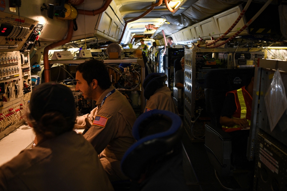 Crew and scientists of the National Aeronautics and Space Administration's (Nasa) DC-8 airborne science laboratory work inside the aircraft. — AFP pic