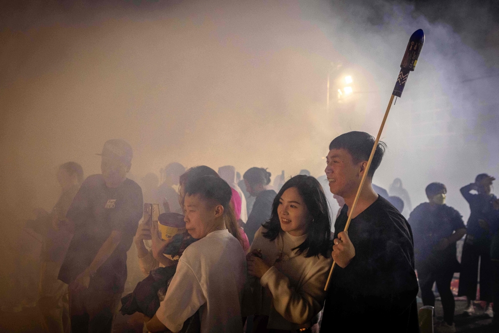 Local residents look at firecrackers and fireworks during the celebration of the Lunar New Year of the Dragon in Macau on February 14, 2024. — AFP pic