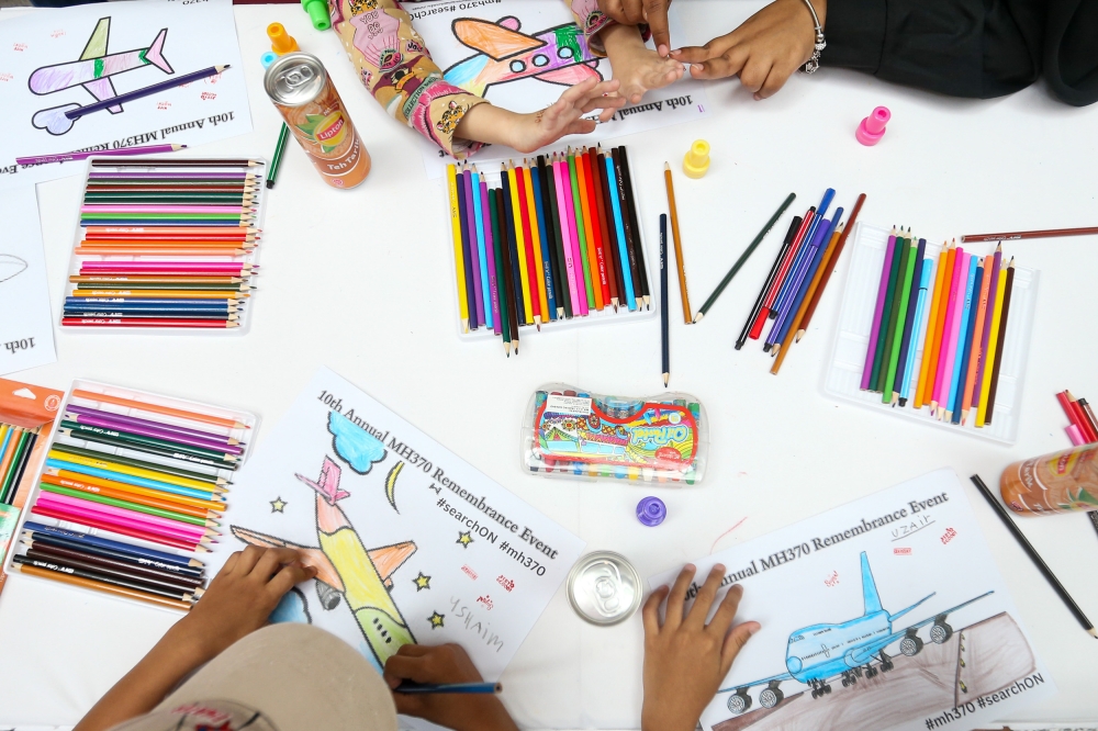 Children are seen colouring pictures of the plane gather during the 10th year commemoration of the disappearance of MH370 in Subang Jaya March 3, 2024. — Picture by Miera Zulyana