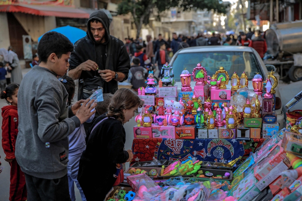 Palestinian children look at toys displayed by a street vendor in Gaza City on March 8, 2024, amid the ongoing conflict between Israel and Hamas militants, as Muslim worshippers prepare to welcome the holy fasting month of Ramadan which begins next week. — AFP pic