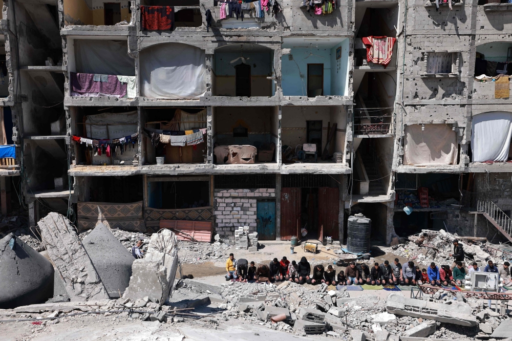 Palestinians perform the first Friday noon prayer of the Muslim holy fasting month of Ramadan over the ruins of of Al-Farouq Mosque on March 15, 2024, destroyed in Israeli bombardment in Rafah in the southern Gaza Strip, amid ongoing battles between Israel and the militant group Hamas. — AFP pic