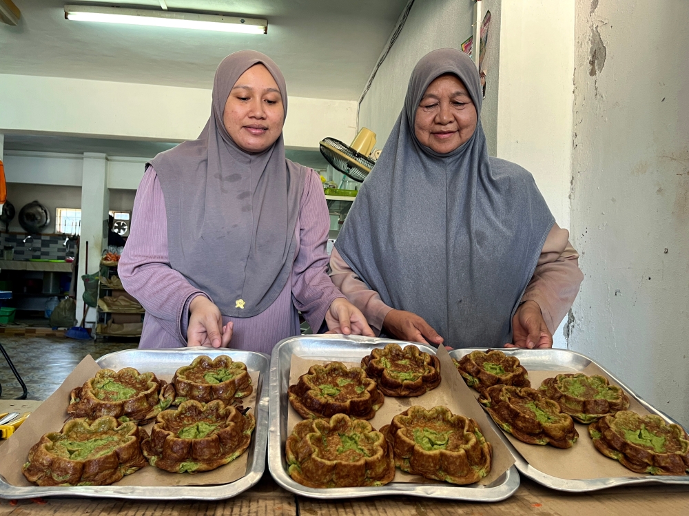 (From left) Nor Asmida Arif and her mother-in-law Rosenani Hamzah show the freshly-made kuih piana in Taman Wangi, Gua Musang March 16, 2024. — Bernama pic