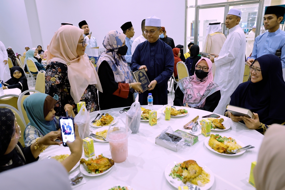 Minister in the Prime Minister’s Department (Religious Affairs) Datuk Mohd Na’im Mokhtar hands a Quran to participants at the King Salman Abdulaziz Al-Saud’s Prize Programme launching ceremony in Putrajaya March 17, 2024. — Bernama pic