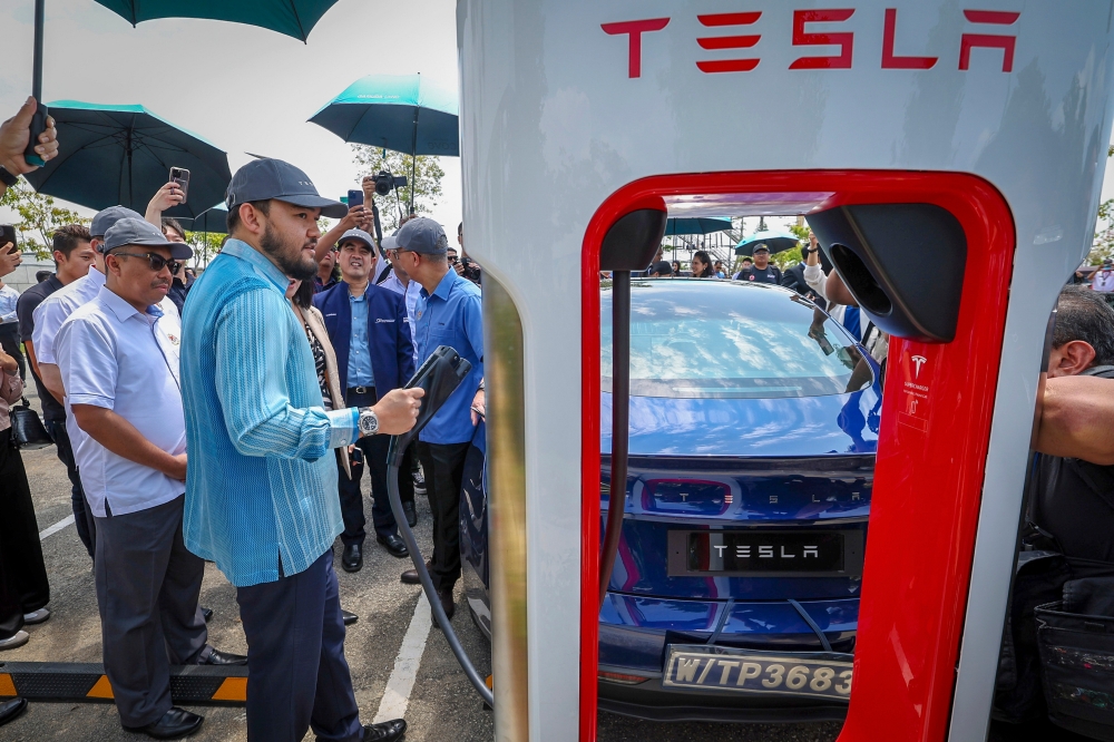 Raja Muda of Selangor Tengku Amir Shah Sultan Sharafuddin Idris Shah charges an electric vehicle the launch of Tesla’s largest supercharging station in South-east Asia at Gamuda Cove in Dengkil March 20, 2024. Also present is Investment, Trade and Industry Minister Datuk Seri Tengku Zafrul Abdul Aziz. — Bernama pic 